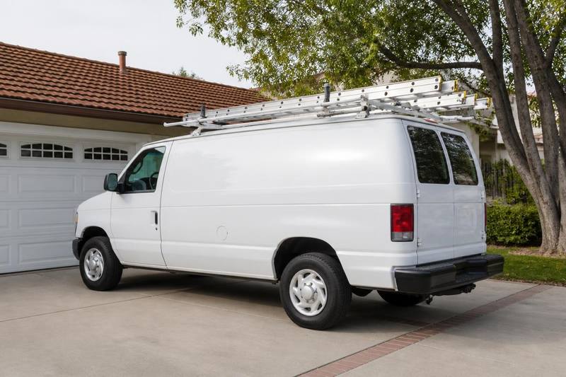 Garage door service van parked in a residential driveway in front of an open garage